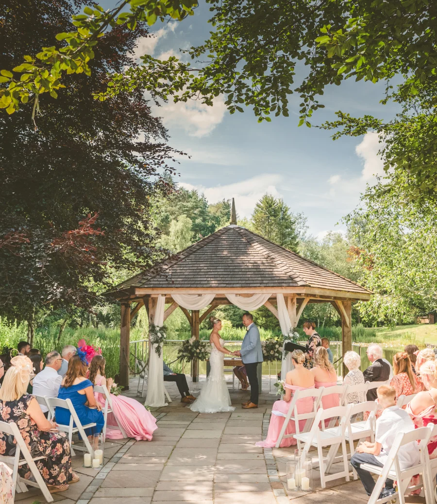 Outdoor wedding ceremony at the garden gazebo, with guests seated on the terrace